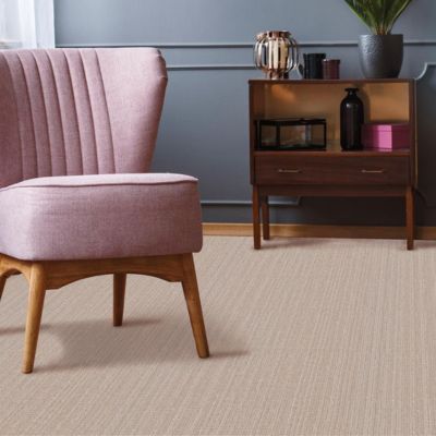 patterned beige carpets in a classy living room with pink chair and blue accent wall